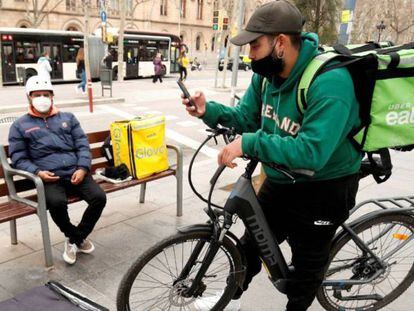 Repartidores de Glovo, Deliveroo y Uber Eats esperando algún servicio en Barcelona, en una foto de archivo. 