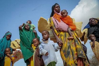 Un grupo de mujeres desplazadas por la sequía camina con sus hijos por las calles de Mogadiscio, la capital de Somalia. 