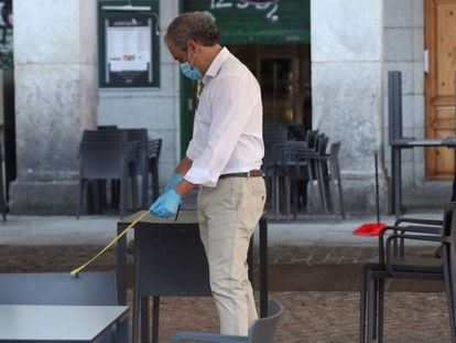 Un camarero comprueba la distancia entre mesas en la terraza de su bar de la Plaza Mayor en Madrid este lunes, primera jornada de la fase 1.