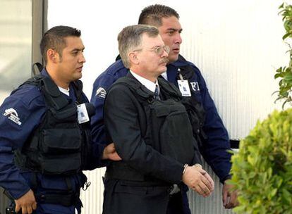 Ricardo Cavallo (izquierda), escoltado por la policía hacia el aeropuerto de Ciudad de México para su entrega a España en 2003.