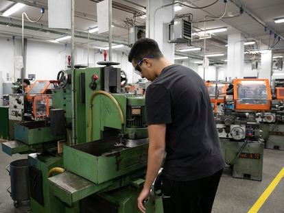 Un estudiante de formación profesional realiza sus prácticas en un taller de mecánica.