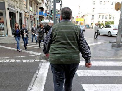 Un hombre con sobrepeso cruza, este mediodía, una calle del centro de Valencia. 