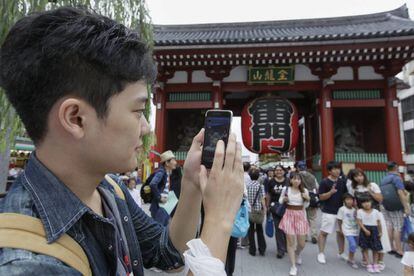 Un joven japonés prueba en su móvil el juego "Pokémon Go" de la compañía Nintendo en Tokio, Japón.