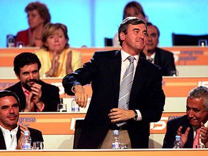 Ángel Acebes, entre Aznar y Arenas, es aplaudido por los miembros de la ejecutiva.