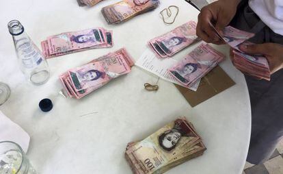 Un camarero cuenta billetes de bol&iacute;var, la divisa venezolana, este martes en Caracas.