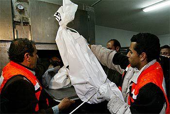 Un equipo médico palestino, con los restos de la suicida.