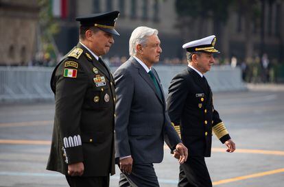El presidente de México, Andrés Manuel López Obrador, cruza el Zócalo entre el secretario de la Defensa y el secretario de Marina.