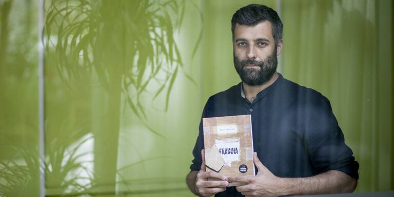 Nacho Carretero, with a copy of the Portuguese edition of 'Farinha'.