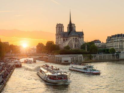 Cruceros tur&iacute;sticos en el r&iacute;o Sena, en Par&iacute;s, con la catedral de Notre Dame al fondo. 