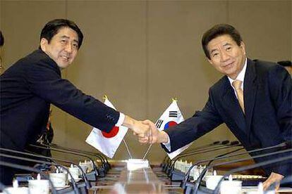 El primer ministro japonés, Shinzo Abe (izquierda), estrecha la mano del presidente surcoreano, Roh Moo-hyun, ayer en Seúl.