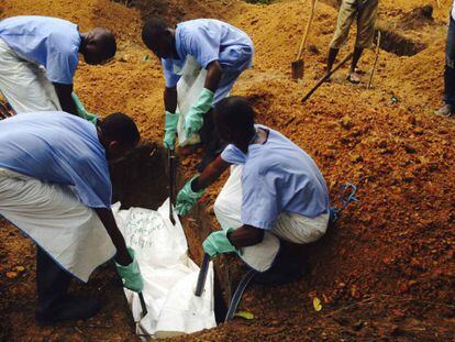 Voluntaris a Sierra Leone enterren un cos de forma segura per evitar el contagi.
