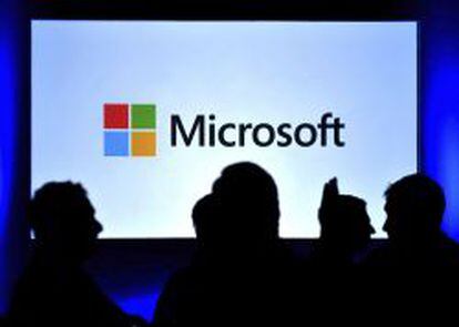 Varias personas ante una pantalla con el logo de Microsoft.