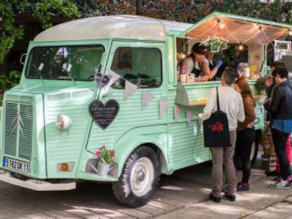 Unos clientes compran comida en un food truck.