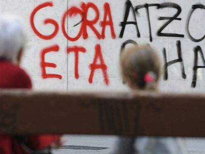 Una mujer y una ni&ntilde;a observan una pintada a favor de ETA en una pared en Vitoria en abril pasado.