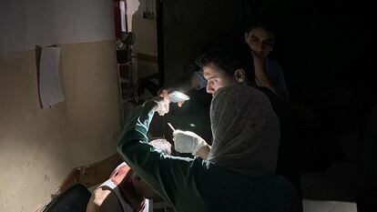 Una captura de pantalla muestra a dos doctores utilizando la linterna de un móvil para tratar a un paciente en un hospital de Gaza este lunes.
 
