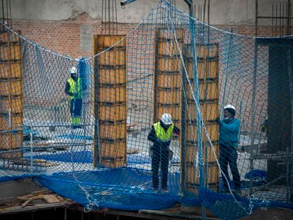 Tres personas trabajan en la construcción de un edificio en Madrid, el 4 de enero.