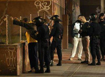 Agentes <i>antidisturbios</i> desplegados en el centro de Alcorcón cachean e identifican a un grupo de jóvenes.