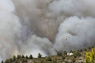 Un helicóptero trabaja en las tareas de extinción del fuego declarado en Ibiza.