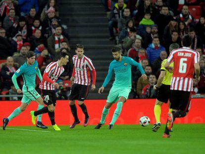 Aduriz golpea la pelota ante Piqué.