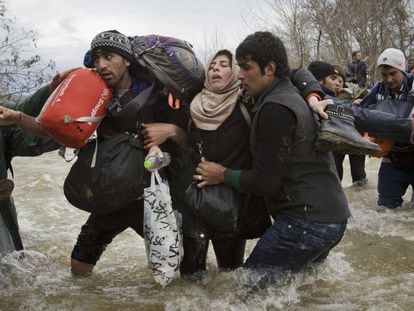 Migrantes atrapados en Idomeni (Grecia) intentan eludir la valla fronteriza, el pasado marzo.