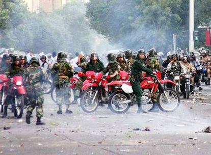 Policías iraníes en motocicletas bloquean el paso a los manifestantes en las calles de Teherán.