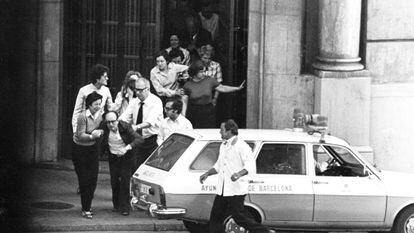 Primera salida de los rehenes del atraco al Banco Central, con una ambulancia del Ayuntamiento aparcada en la plaza de Cataluña de Barcelona.