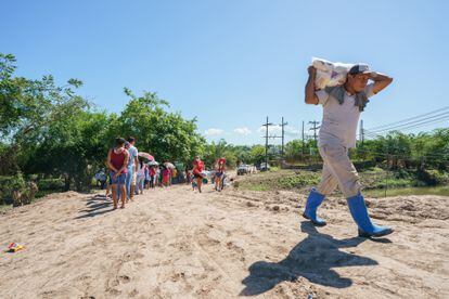 Un hombre carga una bolsa de ayuda humanitaria cerca de Coloma, Honduras.