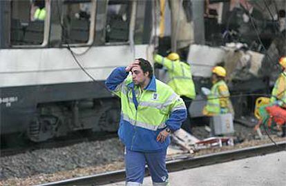 Un empleado del Ayuntamiento de Madrid se lleva la mano a la cabeza ante el vagón que sufrió el atentado en la estación de Santa Eugenia.