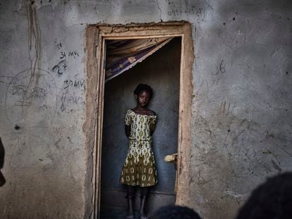 Una niña de la RDC, país del que proviene el 56% de la población del campo de refugiados de Dzaleka, en el marco de la puerta de su casa.