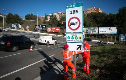 Operarios colocando señales indicativas de la Zona de Bajas Emisiones de Barcelona en 2019, antes de que entrara en vigor.