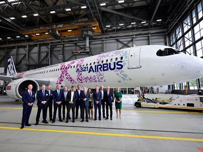 El canciller alemán, Olaf Scholz, y el CEO de Lufthansa, Carsten Spohr (centro), posan junto a un aparato de Airbus A321.