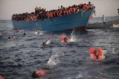 Migrantes, en su mayor&iacute;a eritreos, huyen de una embarcaci&oacute;n en el Mediterr&aacute;neo.