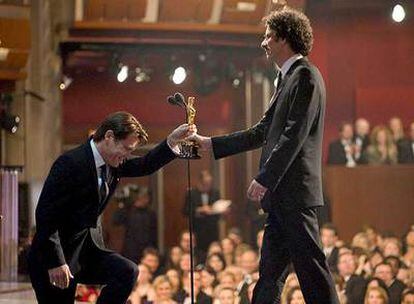 Josh Brolin se arrodilla ante Joel Coen al entregar el Oscar al mejor guión.