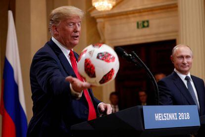 Donald Trump con un balón del fútbol que Putin le ha entregado durante la conferencia de prensa tras la reunión bilateral entre ambos países celebrada en Finlandia.