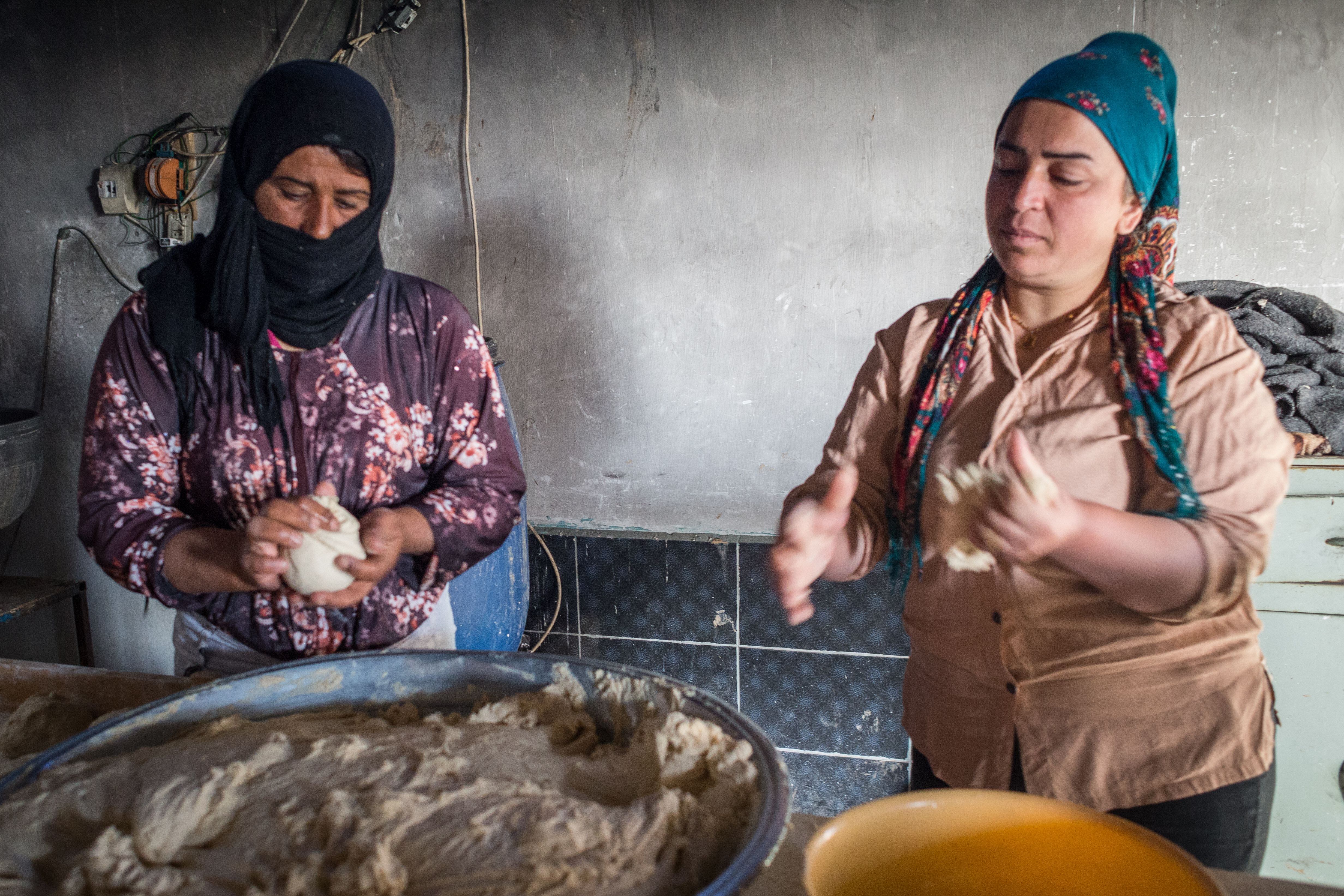 Watha y Dicle, dos aldeanas que preparan masa de pan en la panadería autogestionada del pueblo. El pan se vende tanto en la tienda de Jinwar como en los pueblos vecinos.