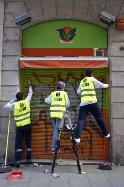 Tres participantes en el plan de limpieza en la calle de Sant Pere m&eacute;s Baix.