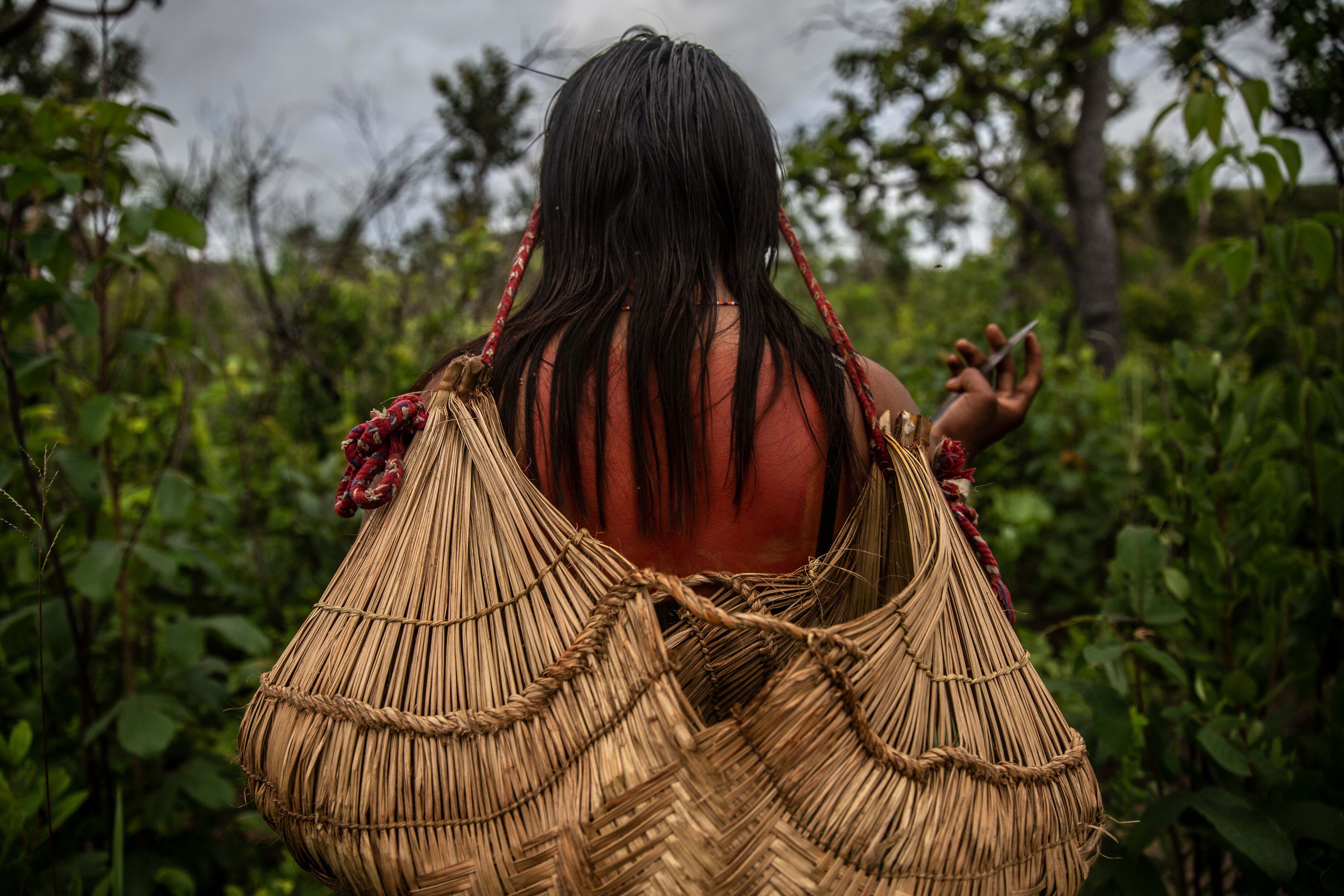 Heloisa se mueve con una cesta de frutas y semillas en la cabeza durante un 'dzomori'.