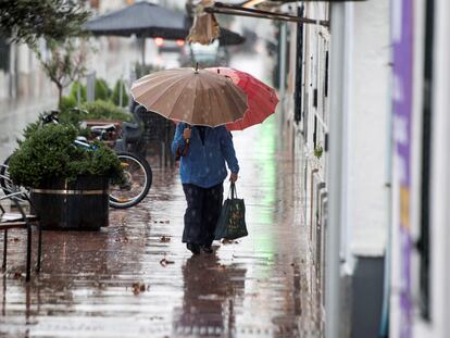 Dos personas caminan bajo la lluvia en Sant Lluís, Menorca, el pasado sábado.