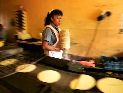 Una trabajadora recoge tortillas recién horneadas en una tienda de la ciudad de México.