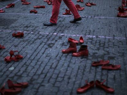 Un hombre camina entre zapatos femeninos en una protesta contra la violencia machista en Barcelona (Espa&ntilde;a), este lunes. 