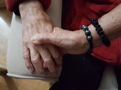 Una mujer coge la mano de su marido, con Alzhéimer.