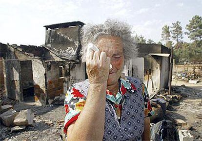 Una mujer llora ante su casa en Chamusca destruída por los incendios.