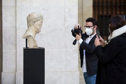 Varias personas fotografía el busto en el Museo de Málaga.