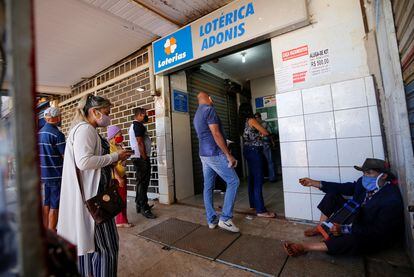 Ciudadanos se forman afuera de un punto de venta de boletos de lotería en el barrio de Ceilandia, en Brasilia, en julio de 2020.