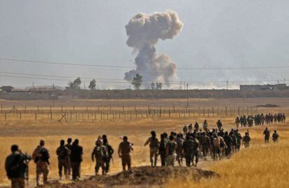 El portavoz de las Operaciones Conjuntas en esa provincia, Yehia Rasul, explicó a Efe que durante el avance de las fuerzas iraquíes en varias localidades en la zona de Al Kuir, 45 kilómetros al este de Mosul, fueron abatidos al menos 60 terroristas y siete de sus vehículos fueron destruidos. En la imagen, combatientes kurdos iraquíes marchan por un camino de la ciudad de Nawaran con una columna de humo al fondo, el 20 de octubre.
