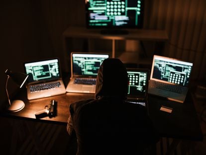 Imagen ilustrativa de un hombre robando información de computadores.