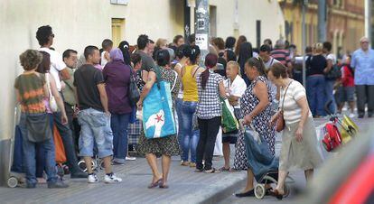 Cola de ciudadanos ante el Banco de los Pobres de Valencia para recibir alimentos b&aacute;sicos. 