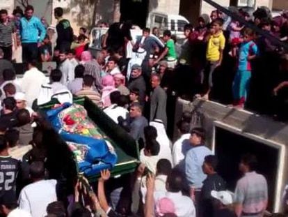 Decenas de ni&ntilde;os observan el funeral de una v&iacute;ctima del ej&eacute;rcito.