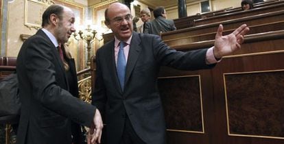 El ministro de Economía, Luis de Guindos, charla con el secretario general del PSOE, Alfredo Pérez Rubalcaba, en el Congreso.