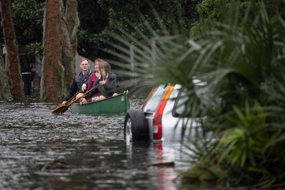 Varias personas reman en una canoa junto a un coche sumergido tras el paso del huracán ‘Ian’ en Orlando.
